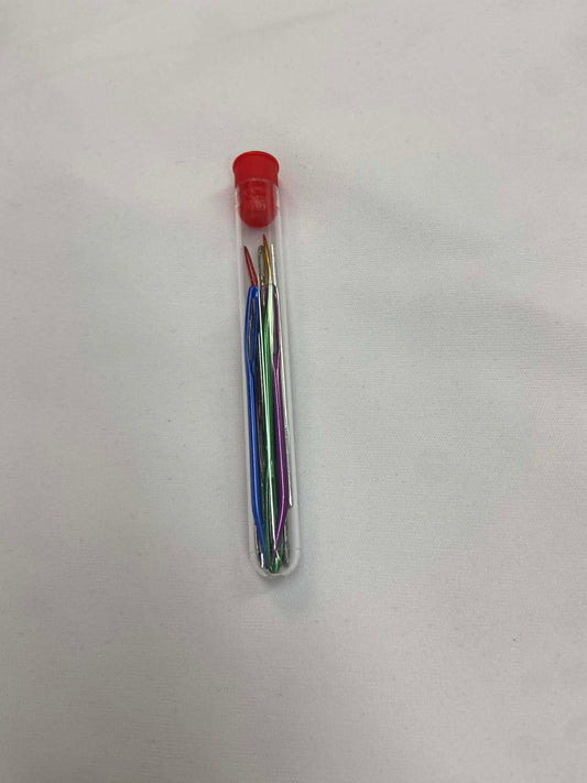 Aiguilles à laine dans un tube de plastique